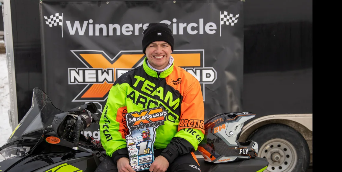 TJ Leach with the number 214 snowmobile in the winner's circle