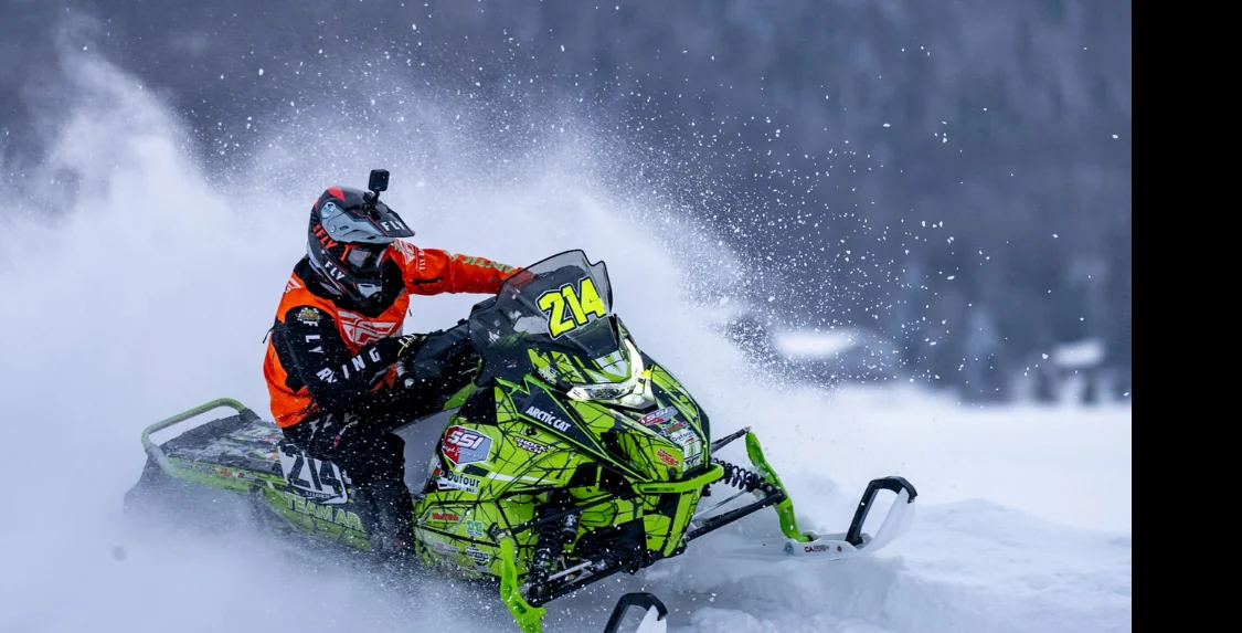 TJ Leach carving an Arctic Cat race sled through deep snow